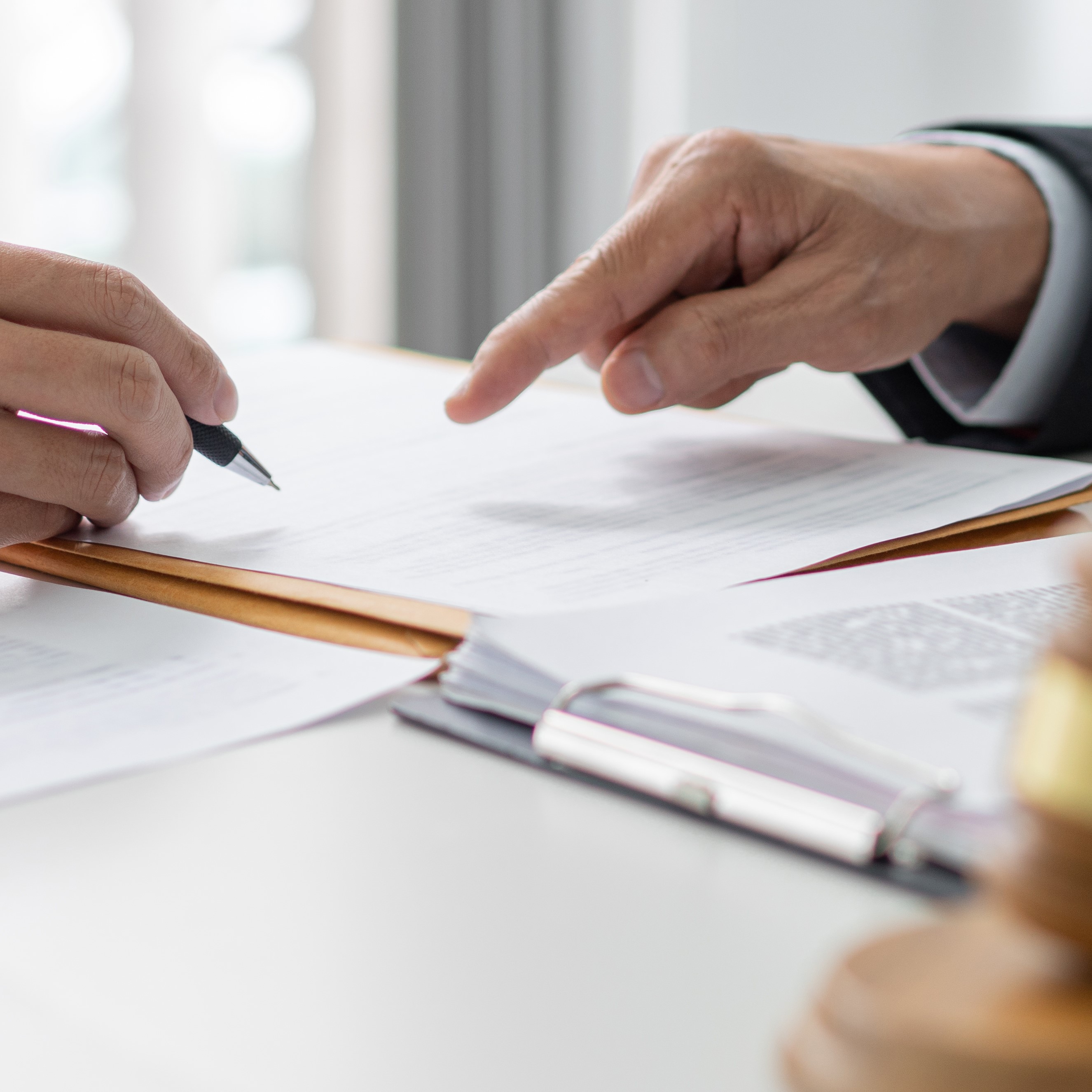 Two lawyers pointing at a document.
