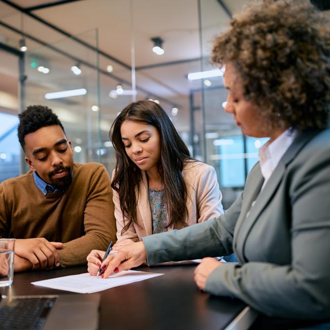 A banker going over a document with a couple.