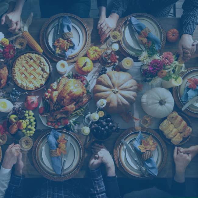 An overhead photo of a family at a dinner table enjoying a thanksgiving feast.