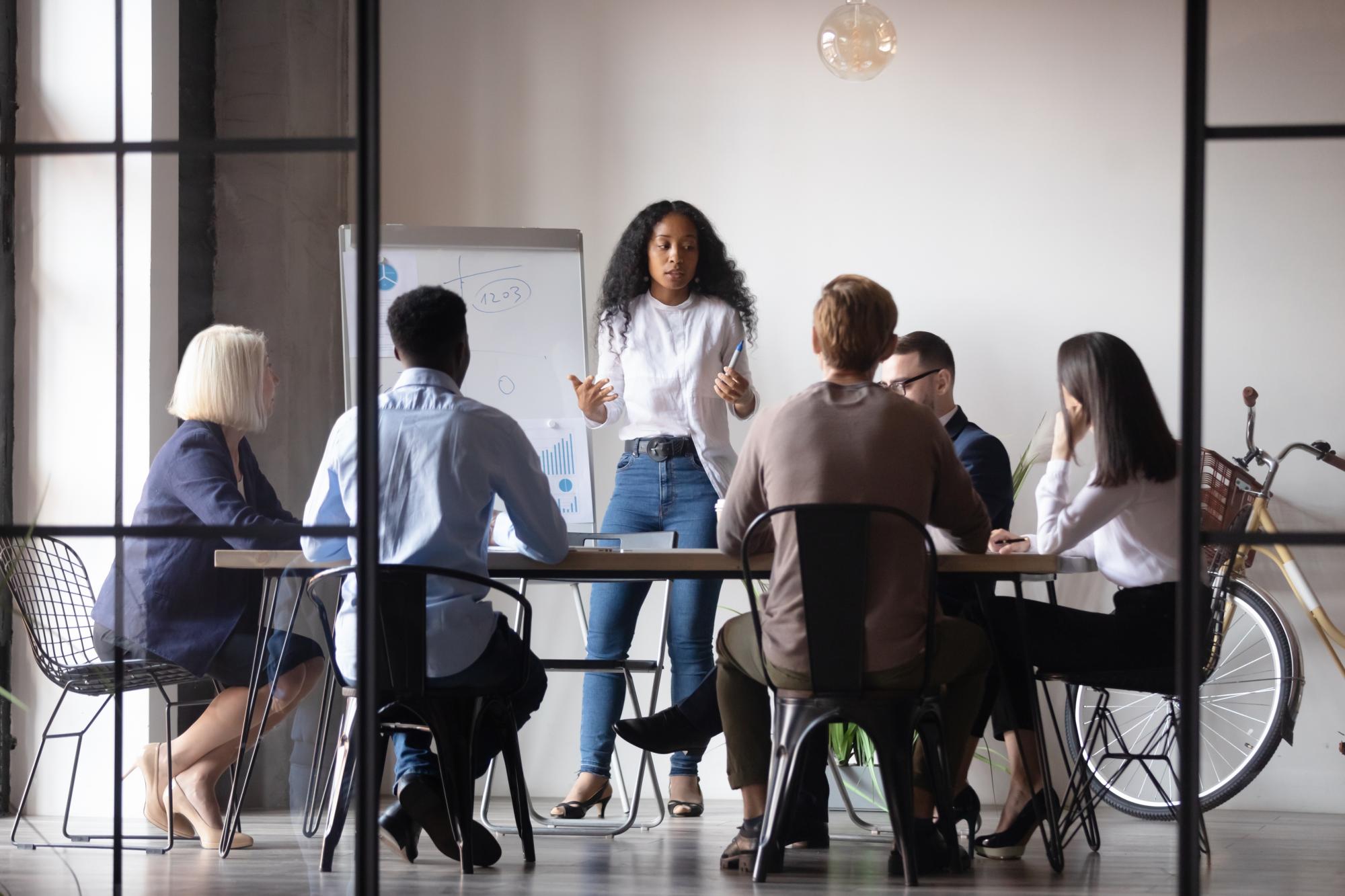 A marketer giving a presentation to a group of colleagues in an office