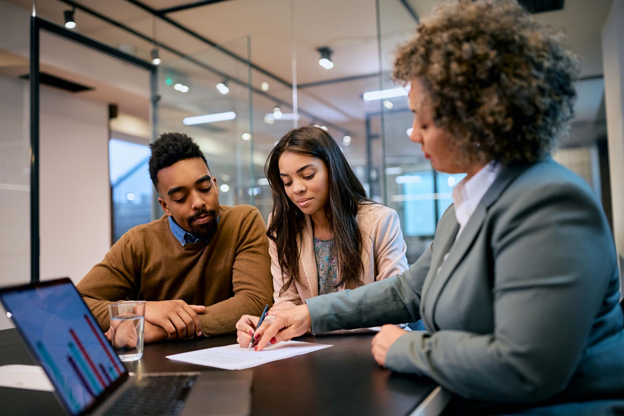 A banker going over a document with a couple.