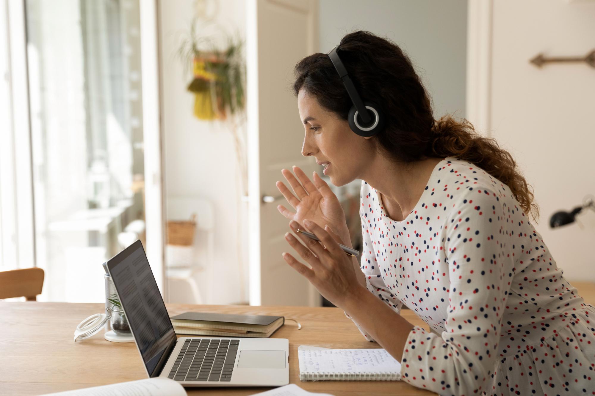 A woman with headphones on a work-related video call.