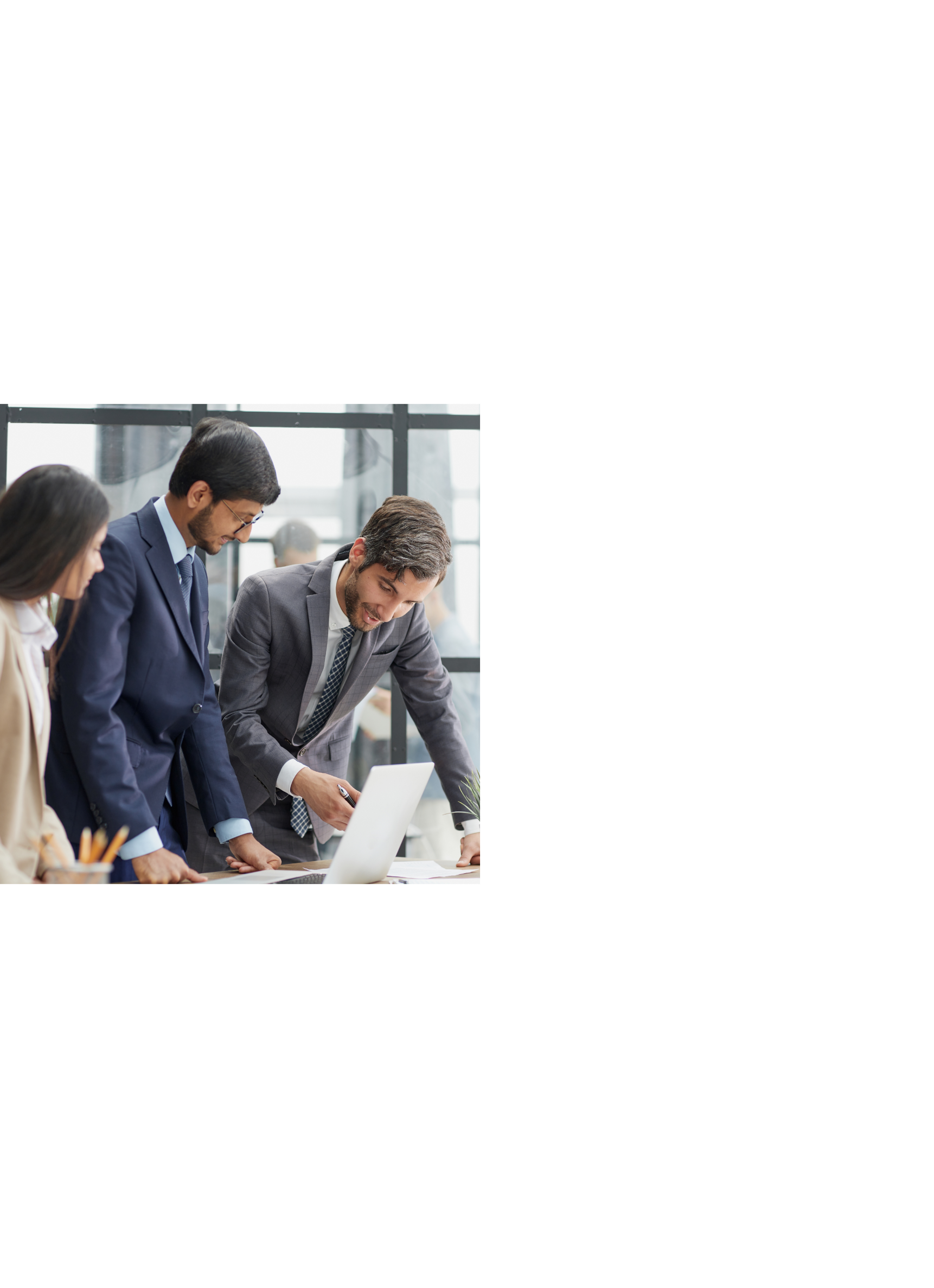 A group of lawyers from India reviewing a document on a laptop.