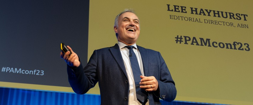 Lee Hayhurst on stage speaking at an event.