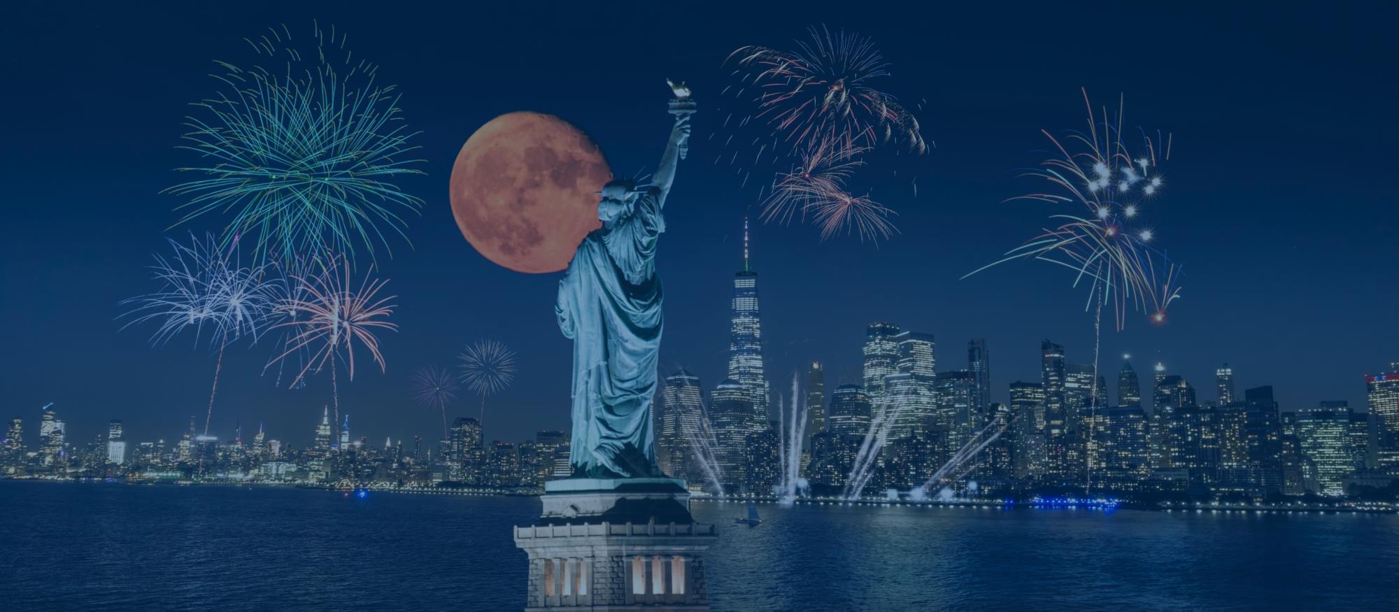 Independence Day fireworks in New York with the statue of liberty visible.