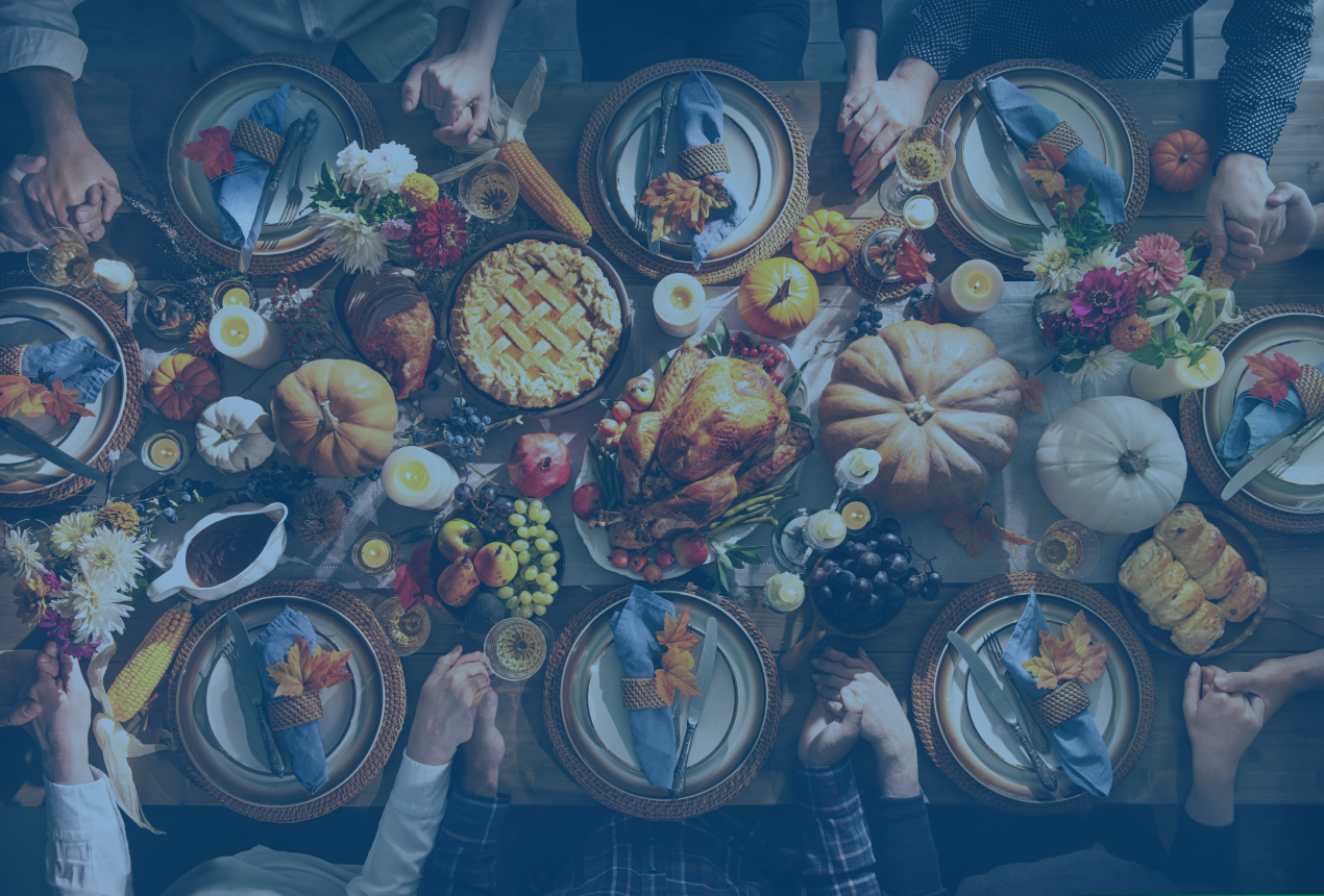 An overhead photo of a family at a dinner table enjoying a thanksgiving feast.